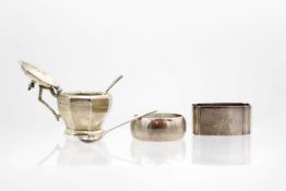 A George VI silver hinge lidded mustard pot, associated spoon, and two silver napkin rings.