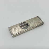 A silver cigarette cutter