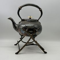 A pewter teapot and warming stand with bark finish