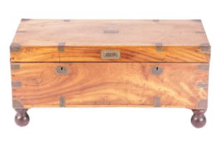 A Victorian brass-bound teakwood campaign trunk with a hinged cover fitted sunken folding bale