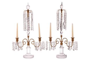 A pair of early Regency cut glass and ormolu candle lustres, each with an urn surmount above a