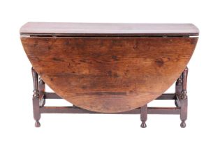 A large late 17th-century oval oak gate table with an inverted baluster turned underframe and