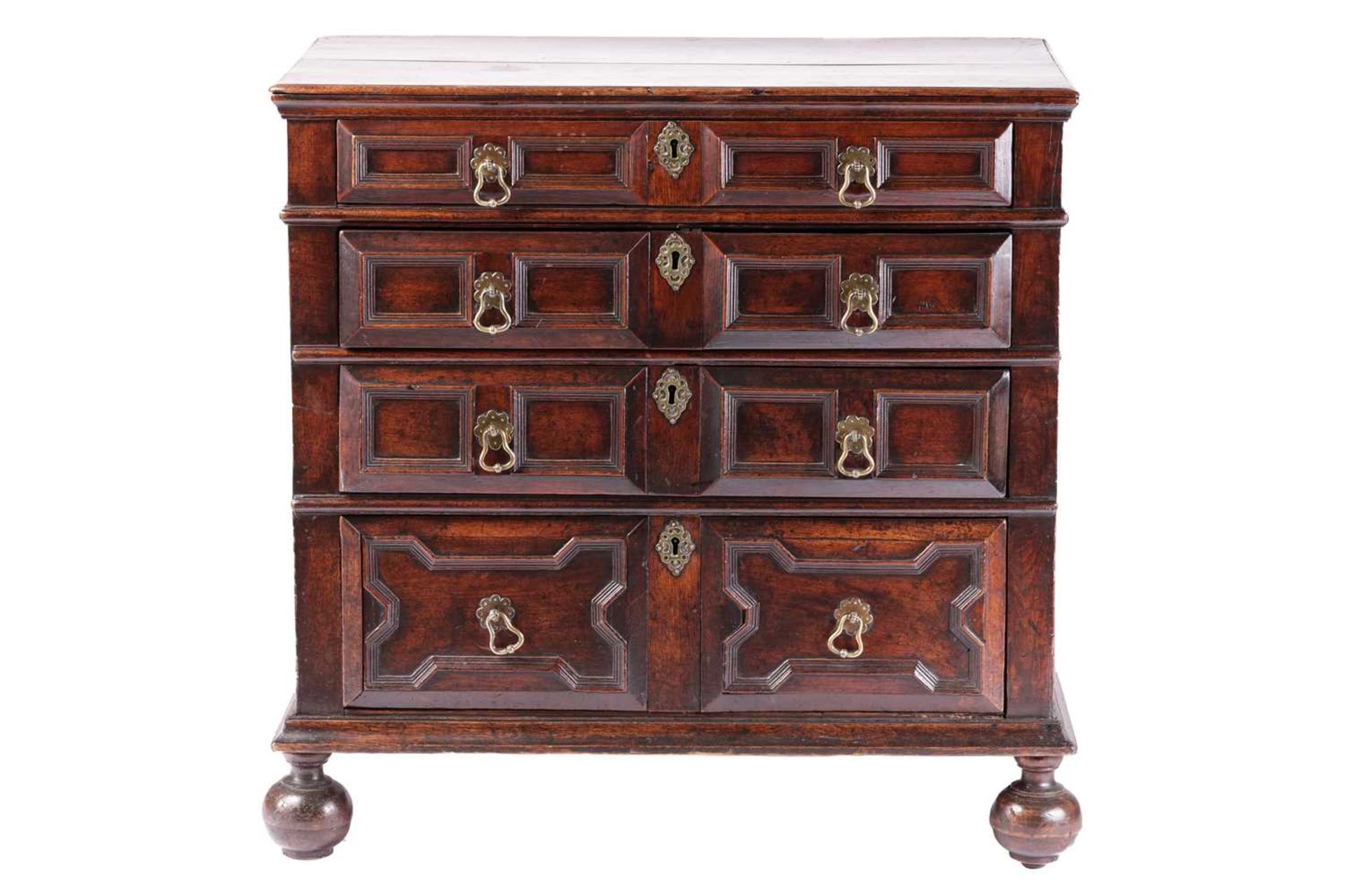 A late 17th-century walnut chest of four long drawers with raised geometric moulded fronts and