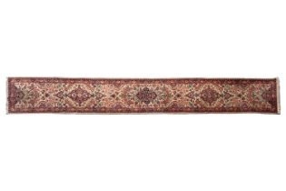 An ivory ground Kerman runner with sprays of flowers within borders, 520 cm x 68 cm