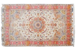 A cream ground machine woven Tabriz style carpet with a central ivory field with circular medalion