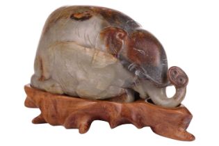A large Chinese green, grey and russet Jade boulder carving of a characterful recumbent elephant,