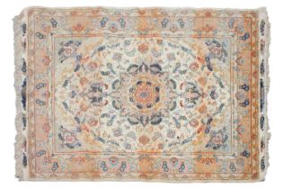 A graduated ivory and peach ground Tabriz rug with a central boss on a scrolling Islimi design