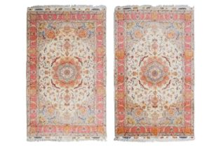 A pair of fine ivory ground Tabriz Carpets with silk detail with tones of pink and grey within Neo-