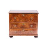 A William & Mary walnut chest of three long drawers, the parquetry top with the central quartered