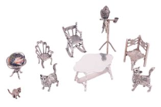 A collection of silver and white metal miniatures comprising a silver parrot on a perch, a silver
