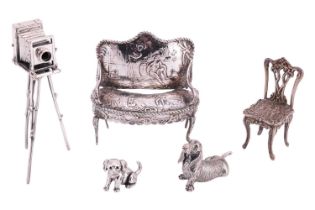 A Collection of silver and white metal figures comprising a silver bow-fronted sofa decorated with