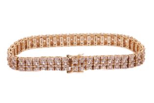 A diamond-set link bracelet in 18ct yellow gold, of floral design, comprising double rows of