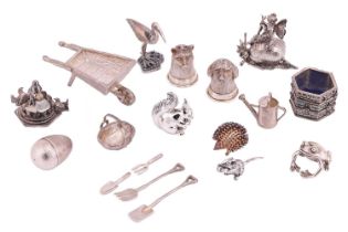 A collection of woodland and garden-themed miniature figures, comprising a silver wheelbarrow with