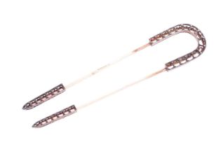 A French hair pin, by Boucheron. Set with small rose-cut diamonds to the horseshoe-shaped frame