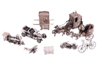 A collection of silver travel-themed miniature figures, featuring various modes of transportation;