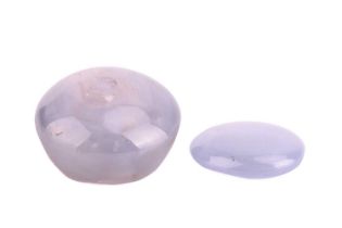 Two loose star sapphires. The first oval cabochon with pale blue body colour approximately