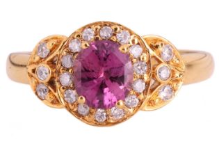 A pink sapphire and diamond cluster ring, set with a central cushion shape pink sapphire measuring