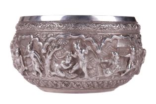 A 19th-century Burmese silver circular bowl, finely embossed in high relief with figures preparing