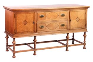 A Morgan and Co. arts and crafts oak sideboard with strung detail to the doors, raised on turned
