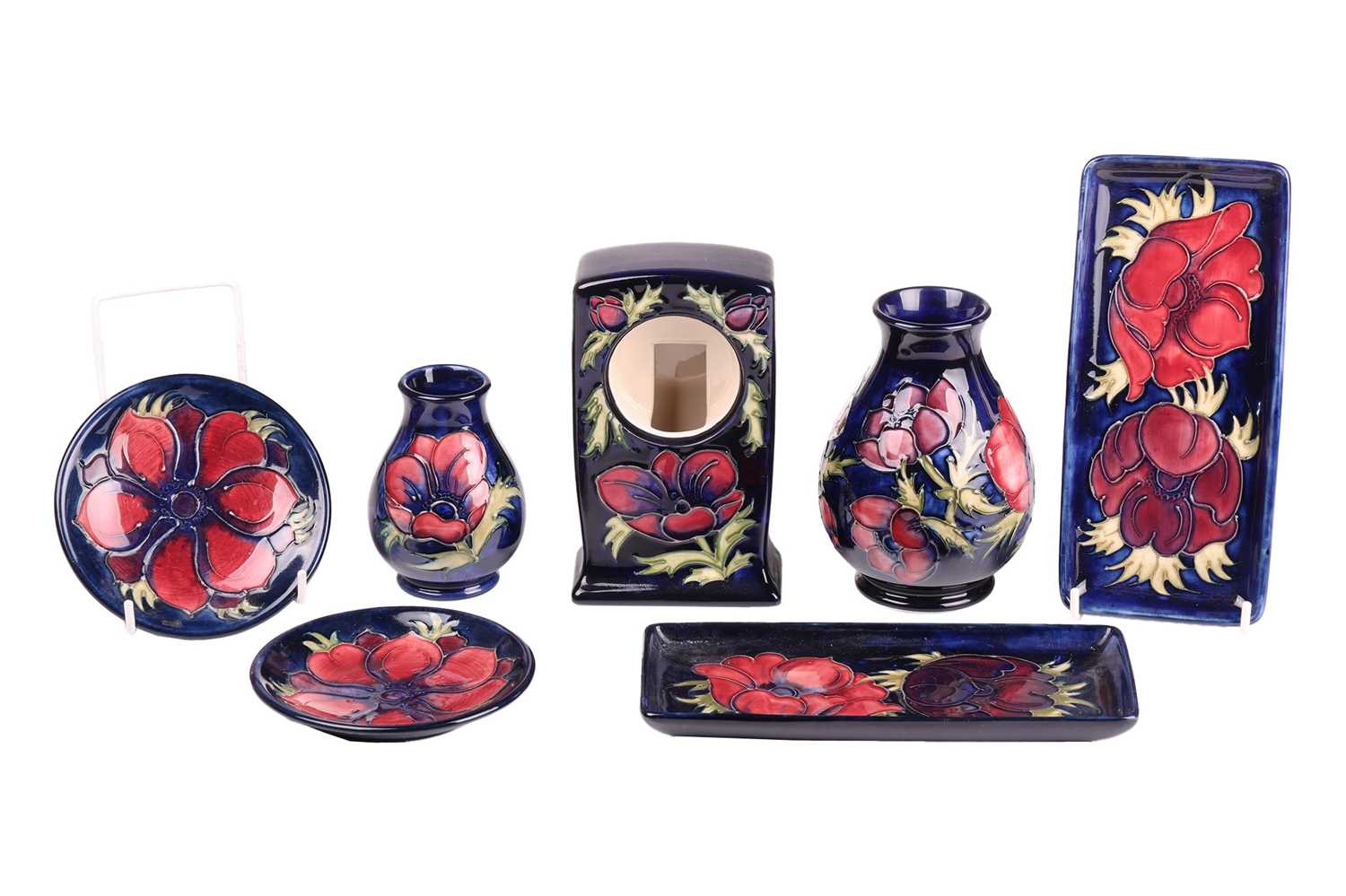 A collection of small Moorcroft items in the Anenome pattern, tube-lined decoration on a dark blue