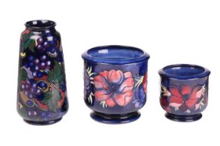 A Moorcroft planter of cylindrical form in the Anenome pattern, tube-lined decoration on a dark blue