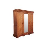 In the manner of Charles Bevan, a blonde Ash mirror door compactum wardrobe in three sections,