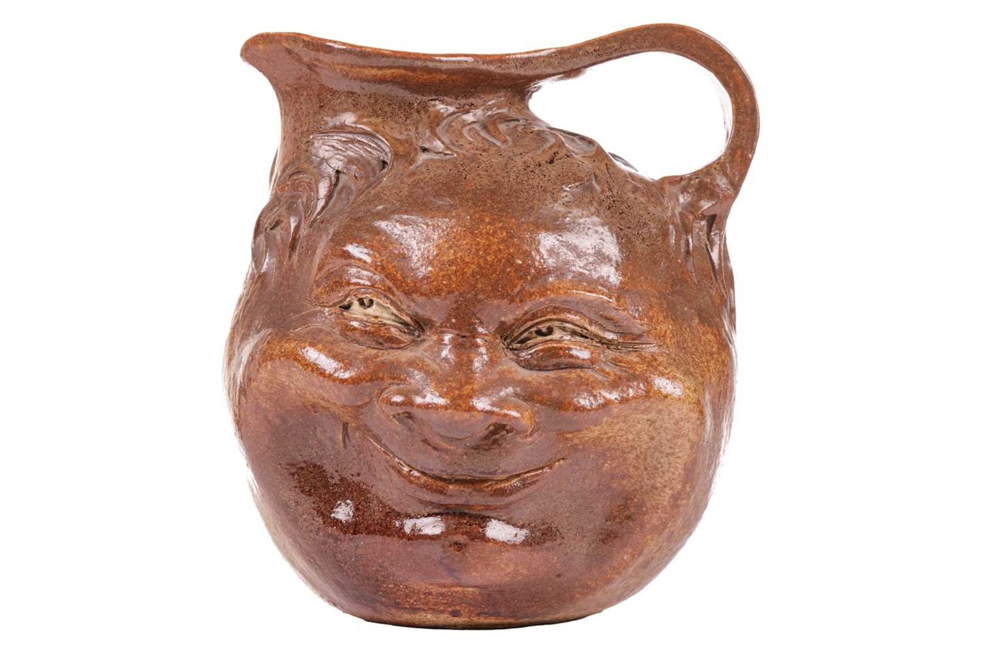 A large Martin Brothers stoneware grotesque face jug, by Robert Wallace Martin, each side