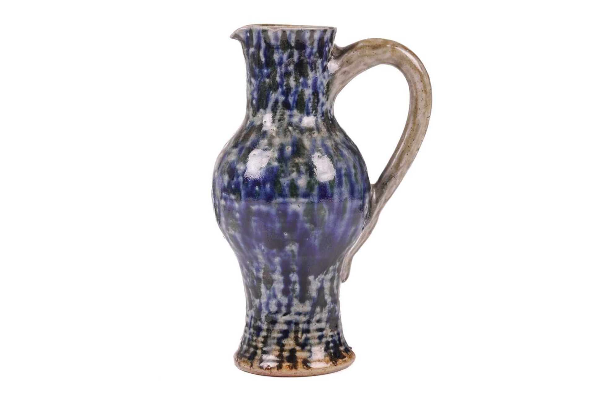 A late 19th century Martin Brothers stoneware jug, of bellied form with mottled blue glaze on a