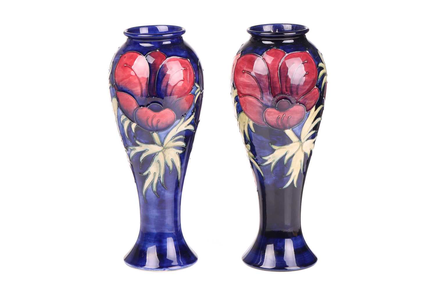 A near pair of Walter Moorcroft tall vases, in the Anenome pattern, tube-lined decoration on a