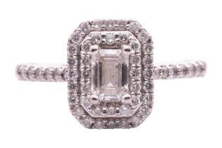 A diamond cluster ring, featuring an emerald cut diamond within a two row border of round
