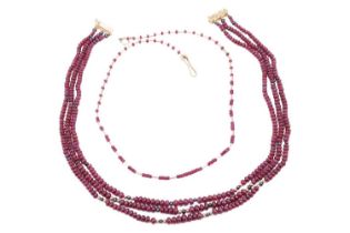 Two ruby beaded necklaces with 18ct gold clasps; the first containing three strands of ruby beads