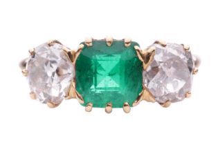 An emerald and diamond three stone ring, the central square cut emerald measuring 7.1 x 7.1 x 4.5mm,