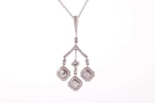 A diamond pendant in a chandelier design with a triple drop, each drop featuring a square emerald