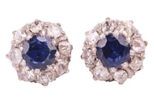 A pair of sapphire and diamond cluster earrings; the circular cut sapphires in claw mounts above a