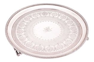 A Victorian silver salver; circular with raised rope twist borders and scroll and foliate
