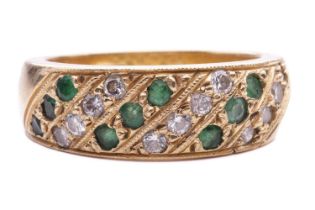 An emerald and diamond-set ring, featuring alternating rows of diamonds and emeralds, grain set in