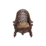 A Bombay Presidency carved rosewood arched back armchair, C1860s profusely carved with Indian strawb