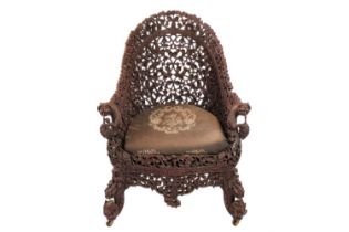A Bombay Presidency carved rosewood arched back armchair, C1860s profusely carved with Indian