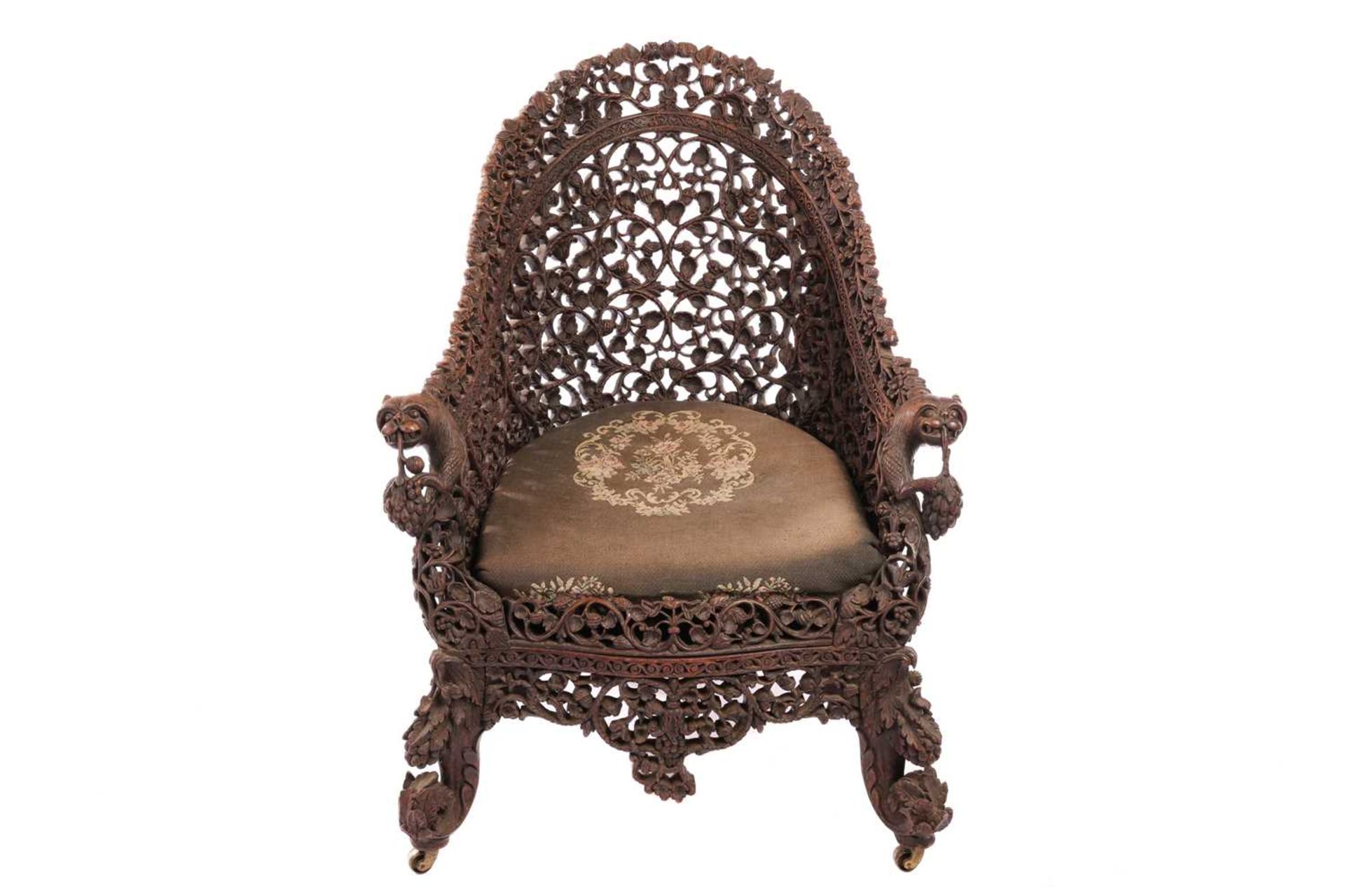 A Bombay Presidency carved rosewood arched back armchair, C1860s profusely carved with Indian strawb