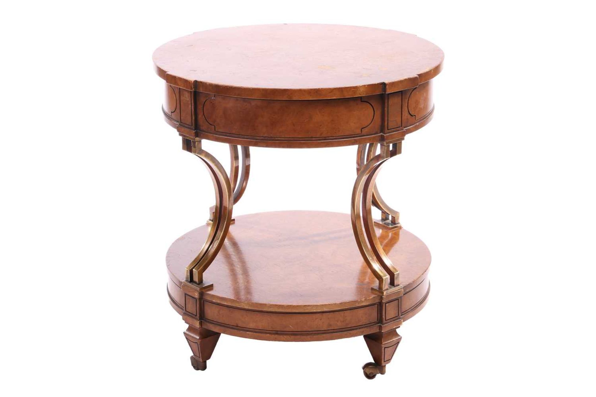 A French Empire-style two-tier drum burr walnut table with concave gilt brass supports over a confor