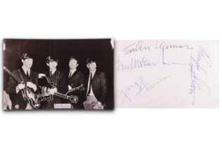 The Beatles: a black and white photographic postcard, signed verso by Paul McCartney, John Lennon,