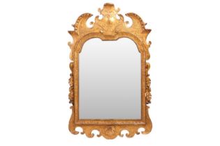 In the Manner of James Moore; A George I carved wood gilt gesso wall mirror, with broken arch