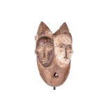 A Baule ‘Janus’ two-faced portrait mask, mid-20th century, 30 cm high. NB: Display stand is for illu