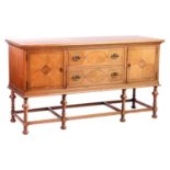 A Morgan and Co. arts and crafts oak sideboard with strung detail to the doors, raised on turned tru