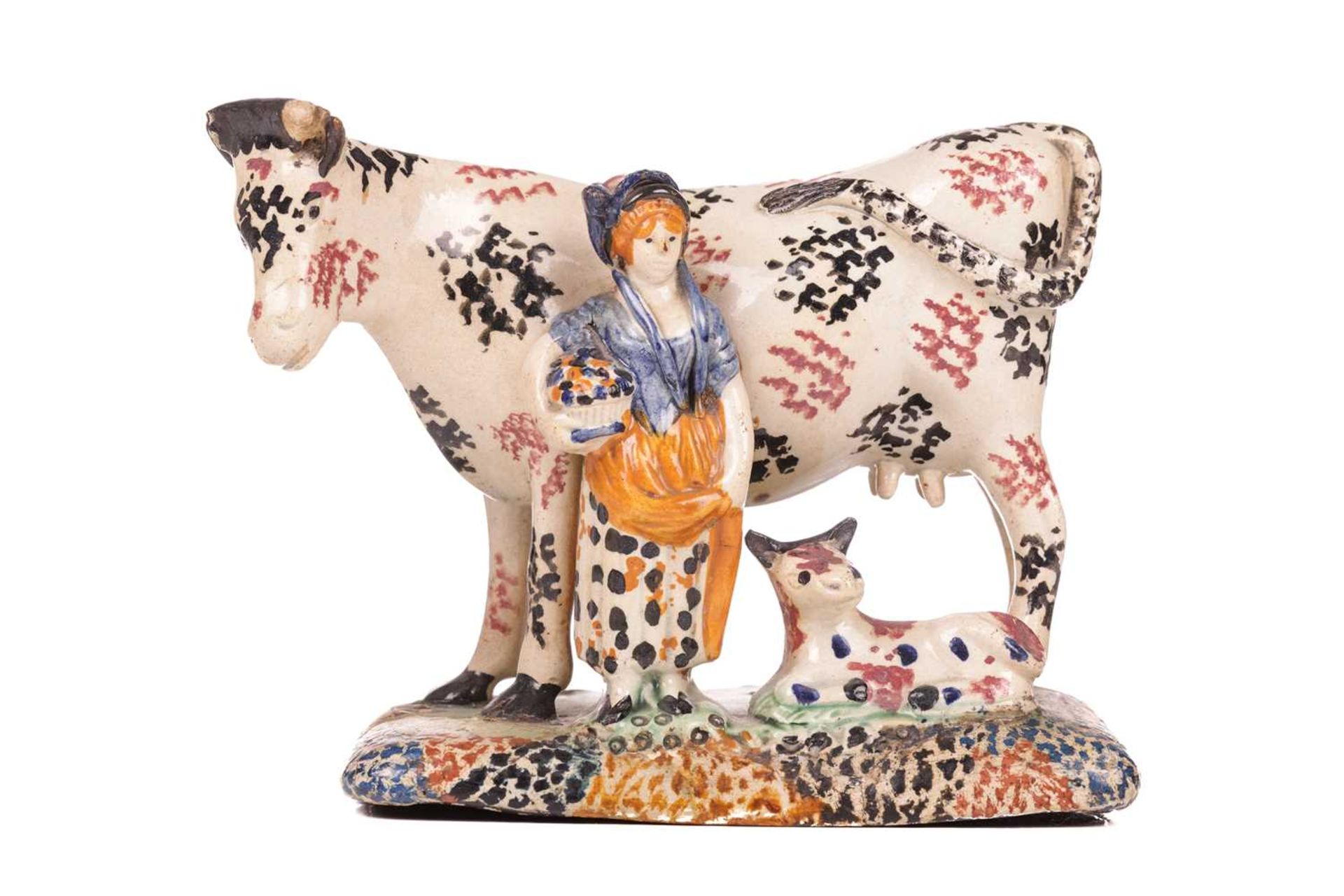 An early 19th-century Prattware ceramic cow, milkmaid and calf figure, circa 1810 with sponged decor