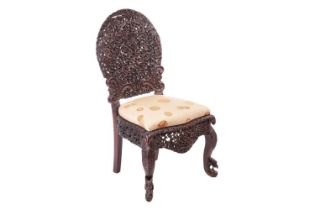 An Indian 'Bombay Carved' padauk slipper chair 19th century, the arched back pierced and carved with