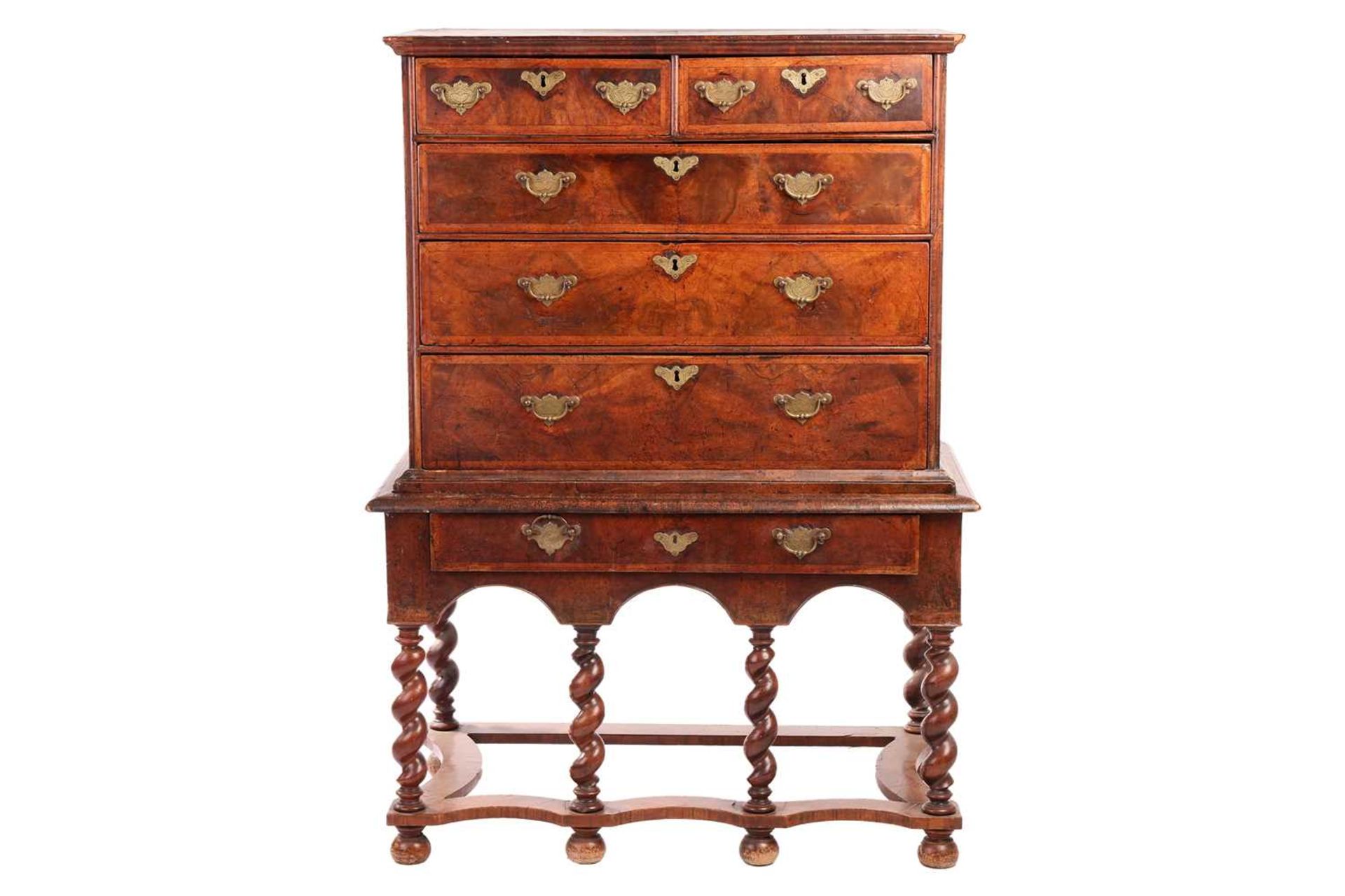 A 17th-century and later figured walnut chest on stand, the upper section with quarter veneered top 