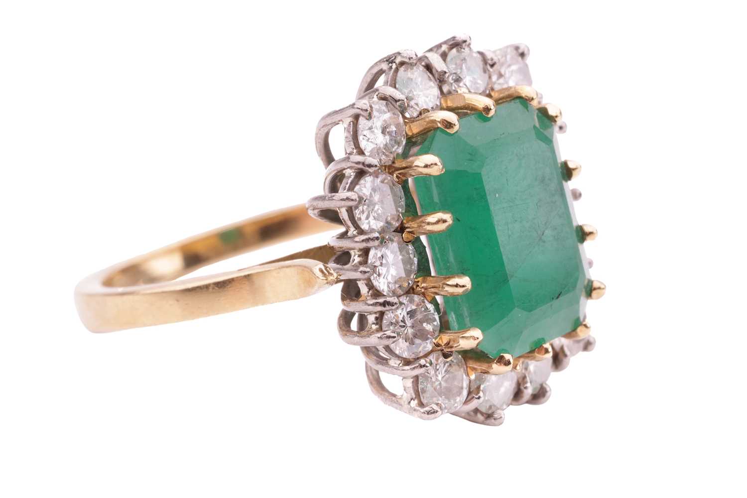 An emerald and diamond cluster ring, set with an emerald measuring 10.8 x 8.2 x 5.2mm, encircled by  - Image 4 of 4