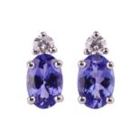 A pair of tanzanite and diamond earrings, the oval tanzanites measuring approximately 6x4mm each, wi