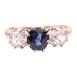 A sapphire and diamond trilogy ring, centred with a cushion-shaped sapphire of intense blue colour, 